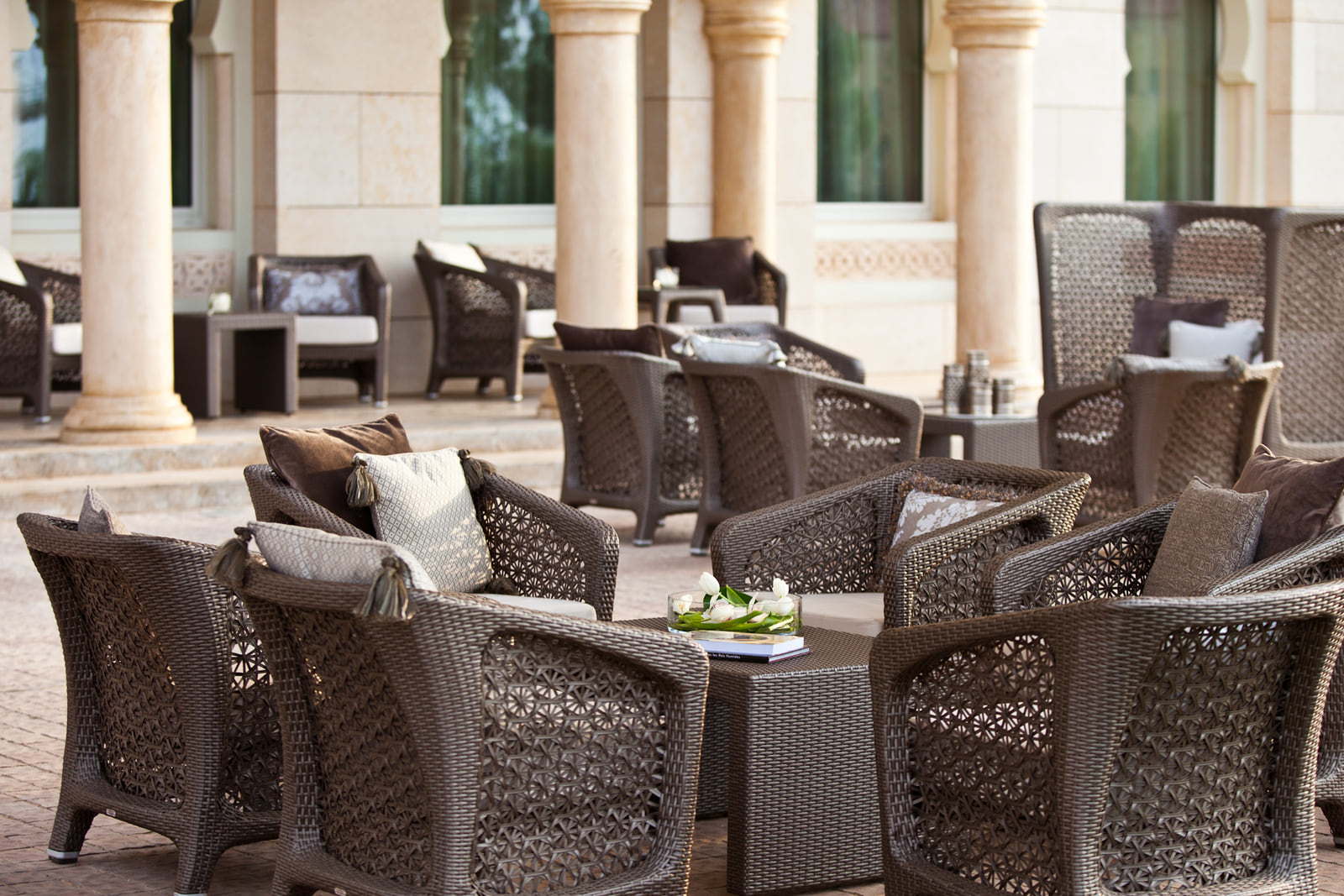 Le patio, fauteuils en rotin sous les colonnes