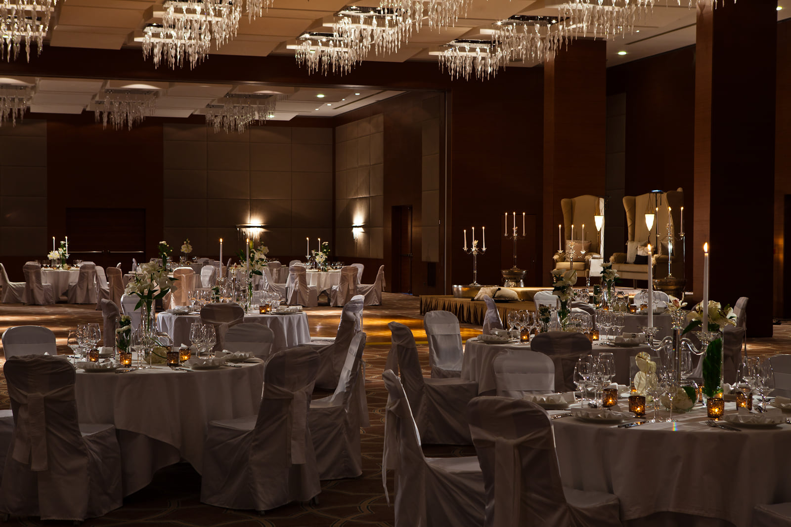 Salle de banquet dressée pour une réception, lustres et tables rondes